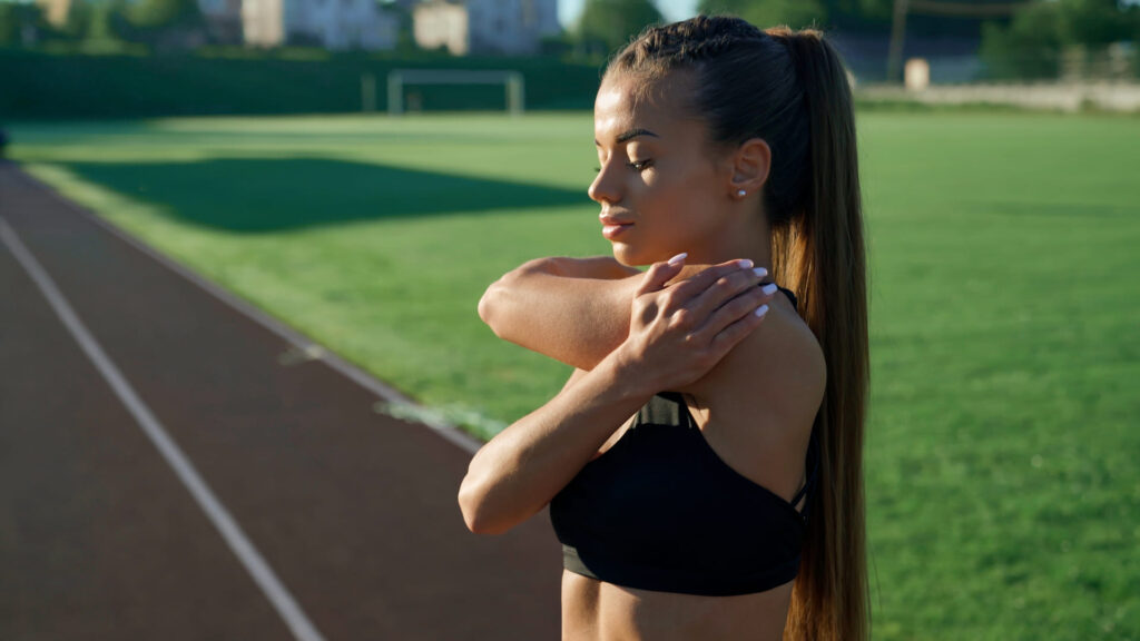 Ragazza che fa stretching in una pista di atletica.