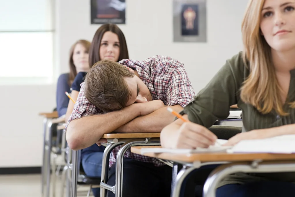 Giovane studente stressato con la testa sul tavolo